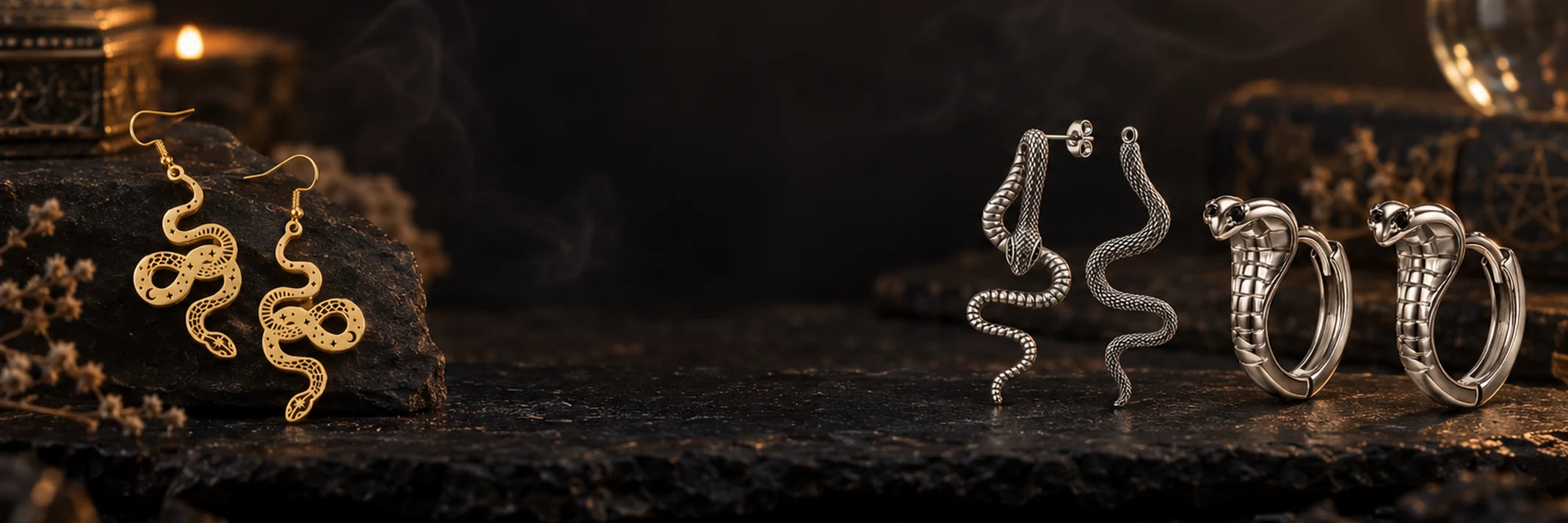 Boucles d'oreilles serpent dorées et argentées posées sur une ardoise sombre